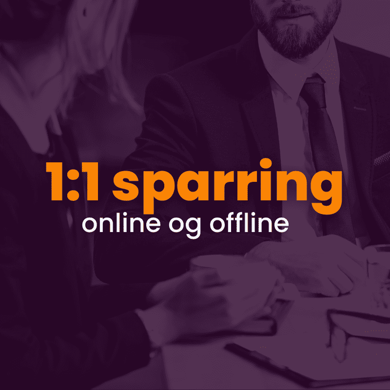 Two people in business attire sit at a table having a discussion. Text overlay reads "1:1 sparring online og offline.
