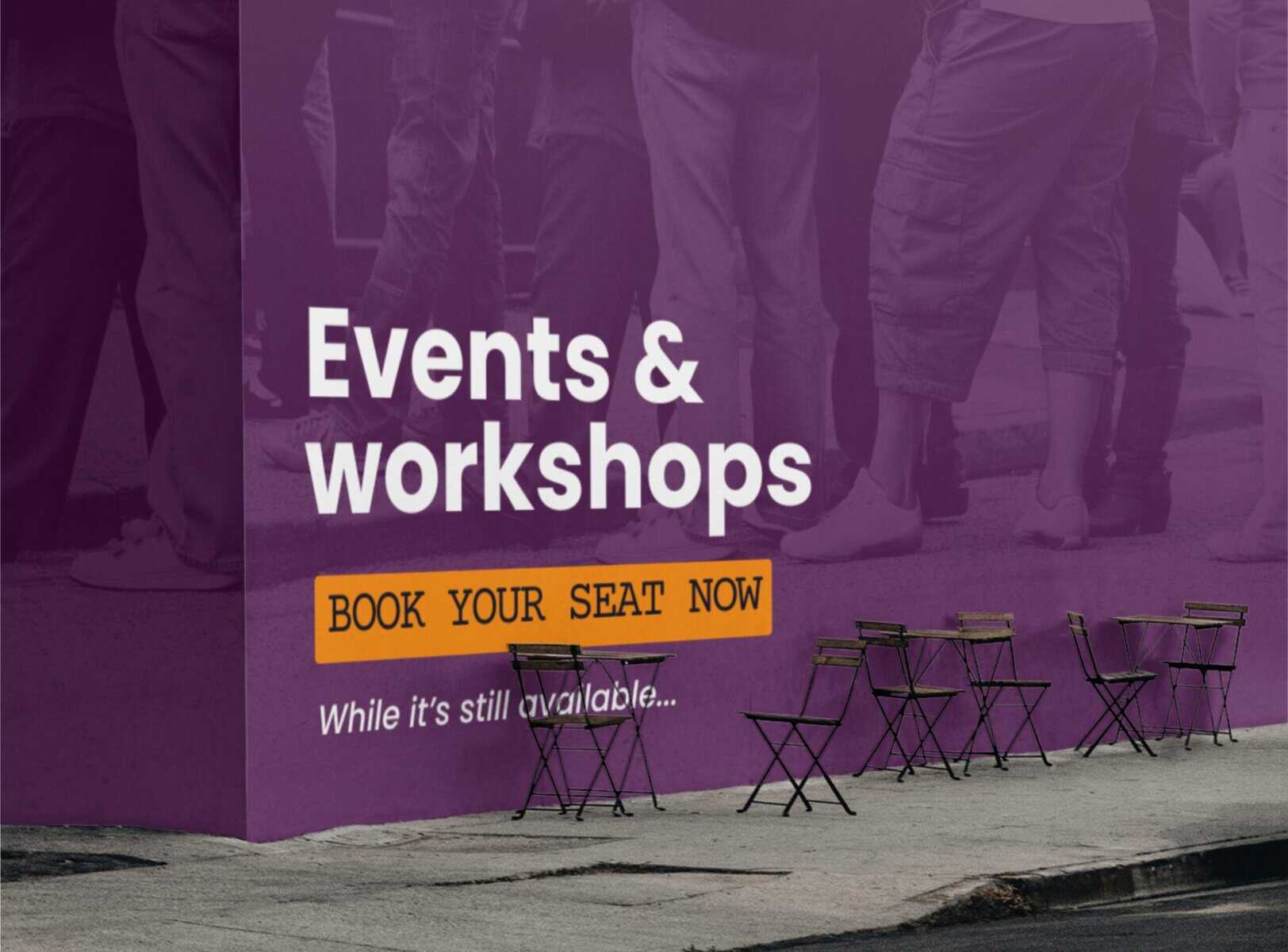 Outdoor sign with large text reading "events & workshops" and "book your seat now" next to empty folding chairs and tables on a sidewalk.