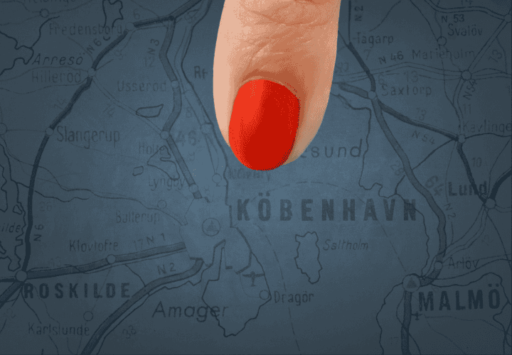Finger pointing at copenhagen on map